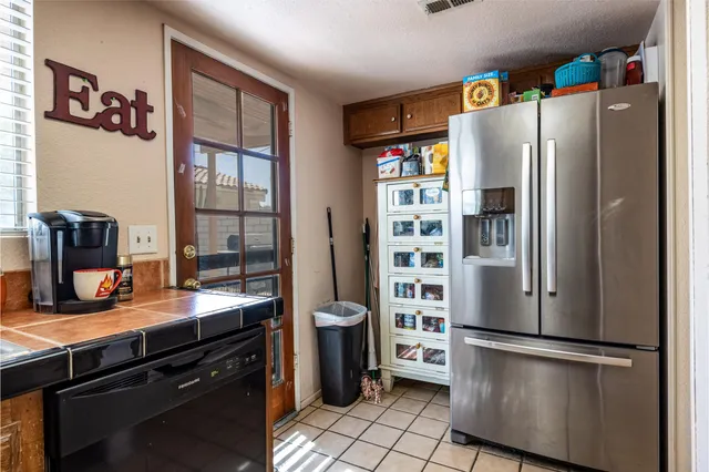 a kitchen with stainless steel appliances a refrigerator and a stove top oven