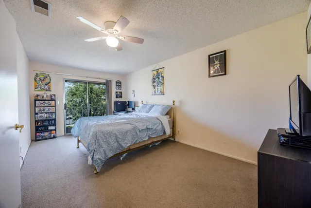a spacious bedroom with a bed and a flat screen tv