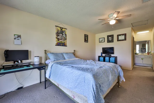 a bedroom with a bed and a ceiling fan