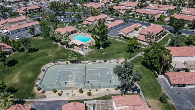 an aerial view of residential houses with outdoor space and parking