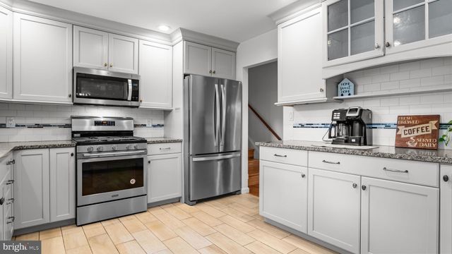 a kitchen with stainless steel appliances granite countertop a refrigerator stove and sink