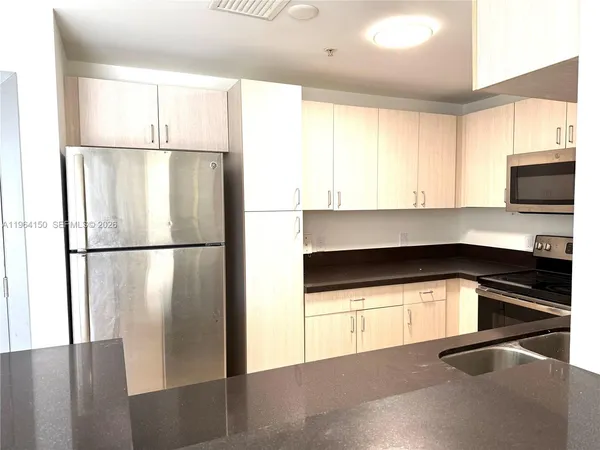 a kitchen with a refrigerator and a stove top oven