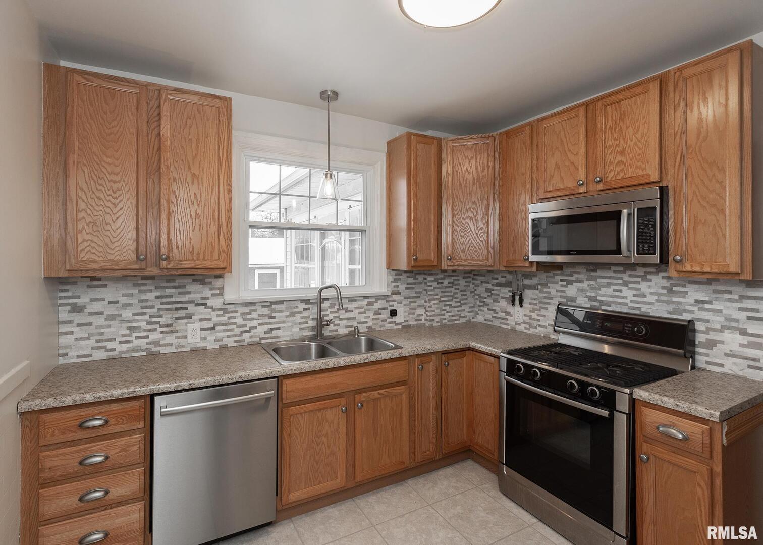 2416 12th Street Moline, IL 61265 - Photo 15 of 41 a kitchen with stainless steel appliances granite countertop white cabinets granite counter tops and a window