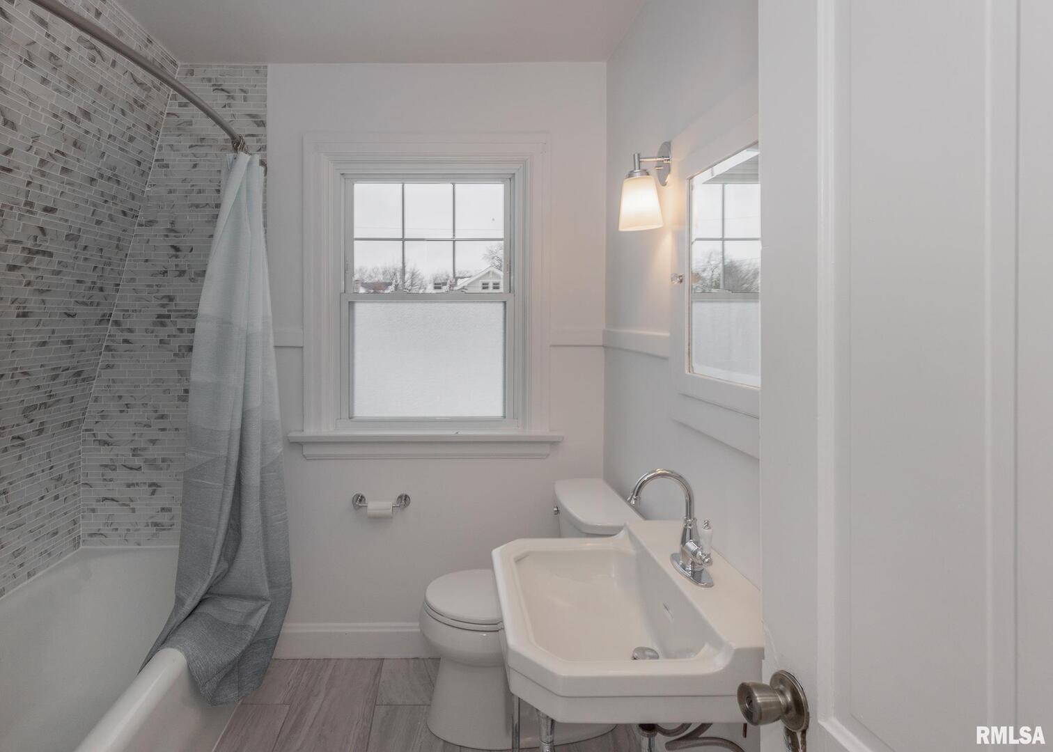 2416 12th Street Moline, IL 61265 - Photo 31 of 41 a bathroom with a sink a toilet and a window