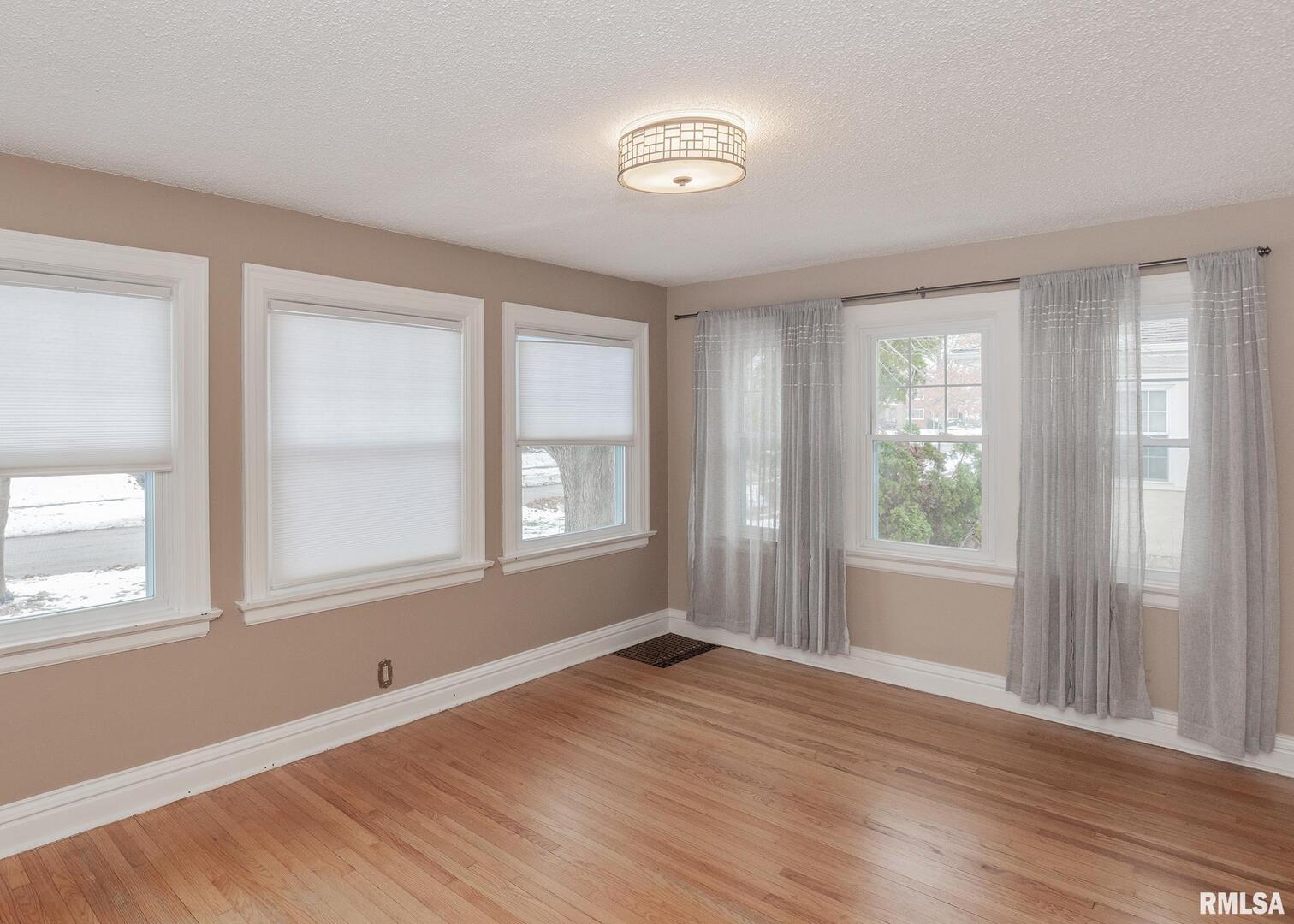 2416 12th Street Moline, IL 61265 - Photo 7 of 41 an empty room with wooden floor and windows
