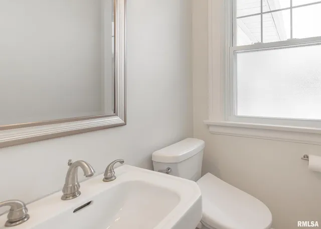 a white toilet sitting next to a bathroom sink