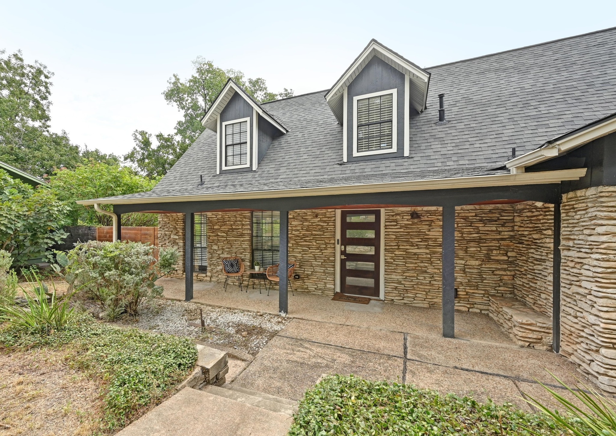 3405 Santa Fe Drive Austin, TX 78741 - Photo 6 of 23 Doorway to property featuring stone siding, covered porch, and a shingled roof