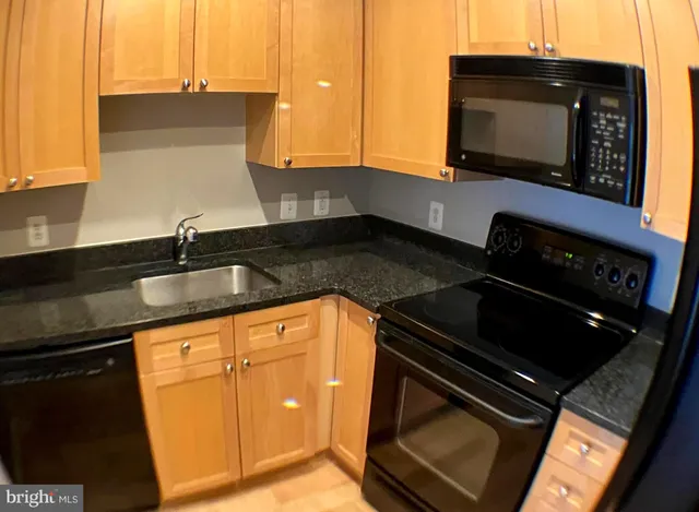 a kitchen with granite countertop a stove and a microwave
