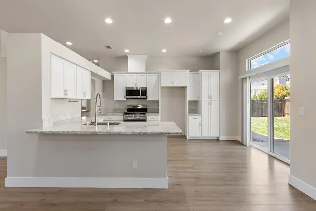 a kitchen with stainless steel appliances sink refrigerator and microwave