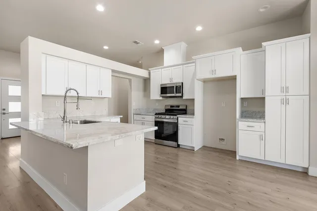 a kitchen with stainless steel appliances a refrigerator sink and microwave