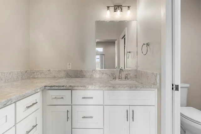 a bathroom with a granite countertop sink and a mirror