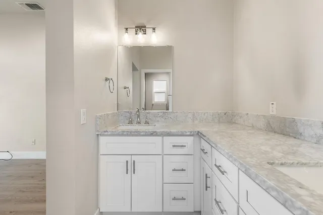 a bathroom with a granite countertop sink and a mirror