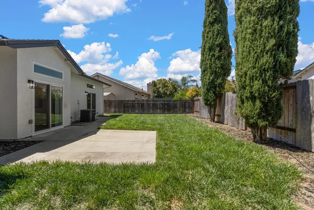 a front view of a house with a yard and trees