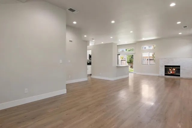 a view of an empty room with wooden floor and a cabinet