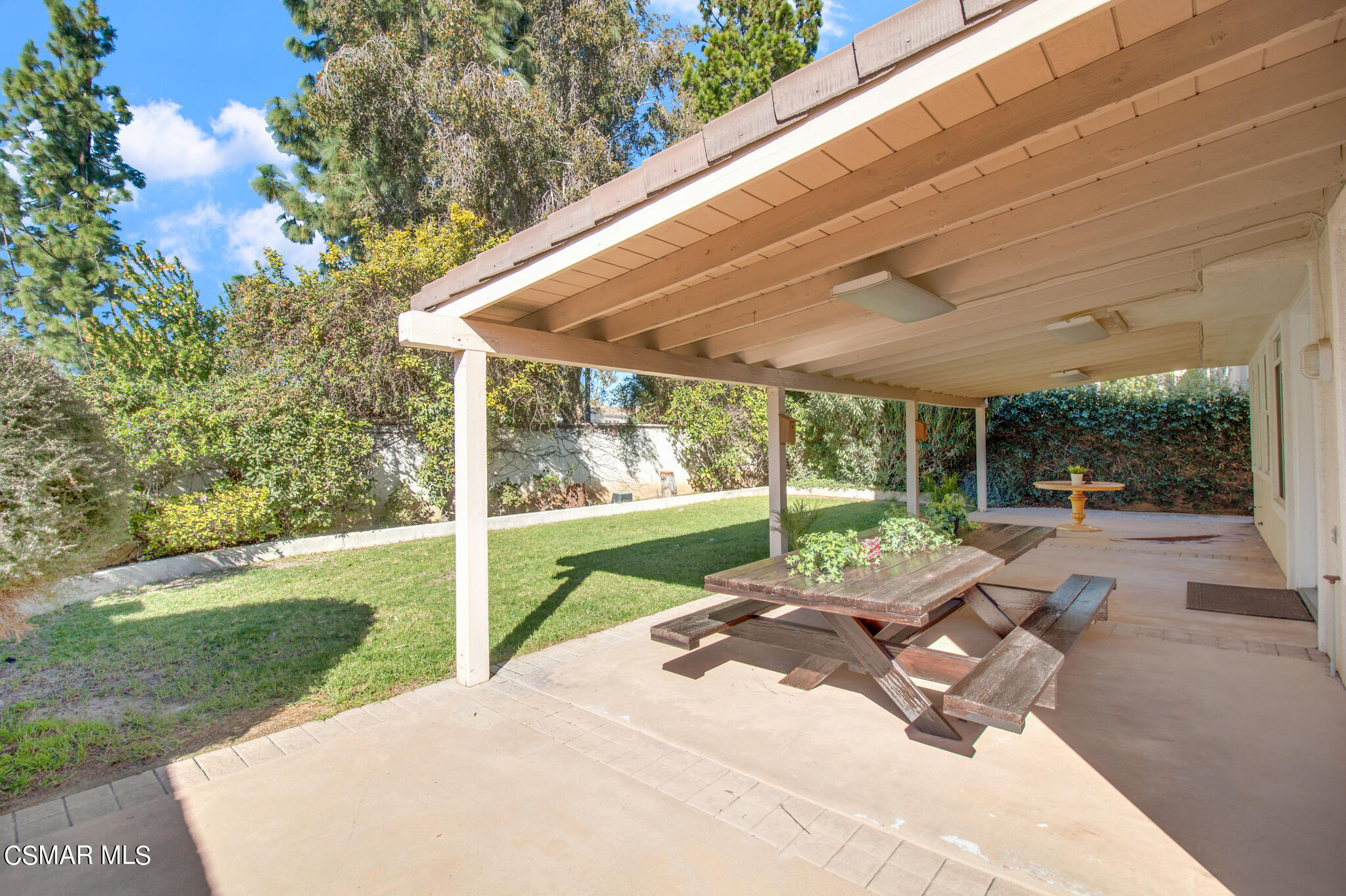 11603 Pinedale Road Moorpark, CA 93021 - Photo 50 of 54 a view of a patio with table and chairs under an umbrella with large trees