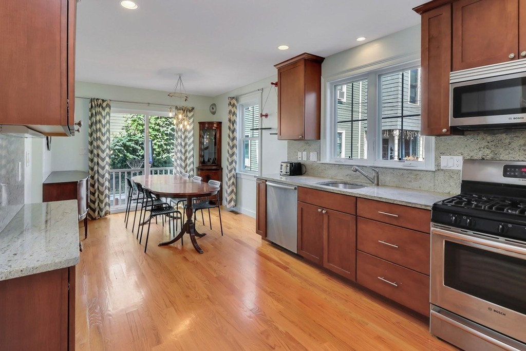 a kitchen with stainless steel appliances granite countertop wooden floors and stove