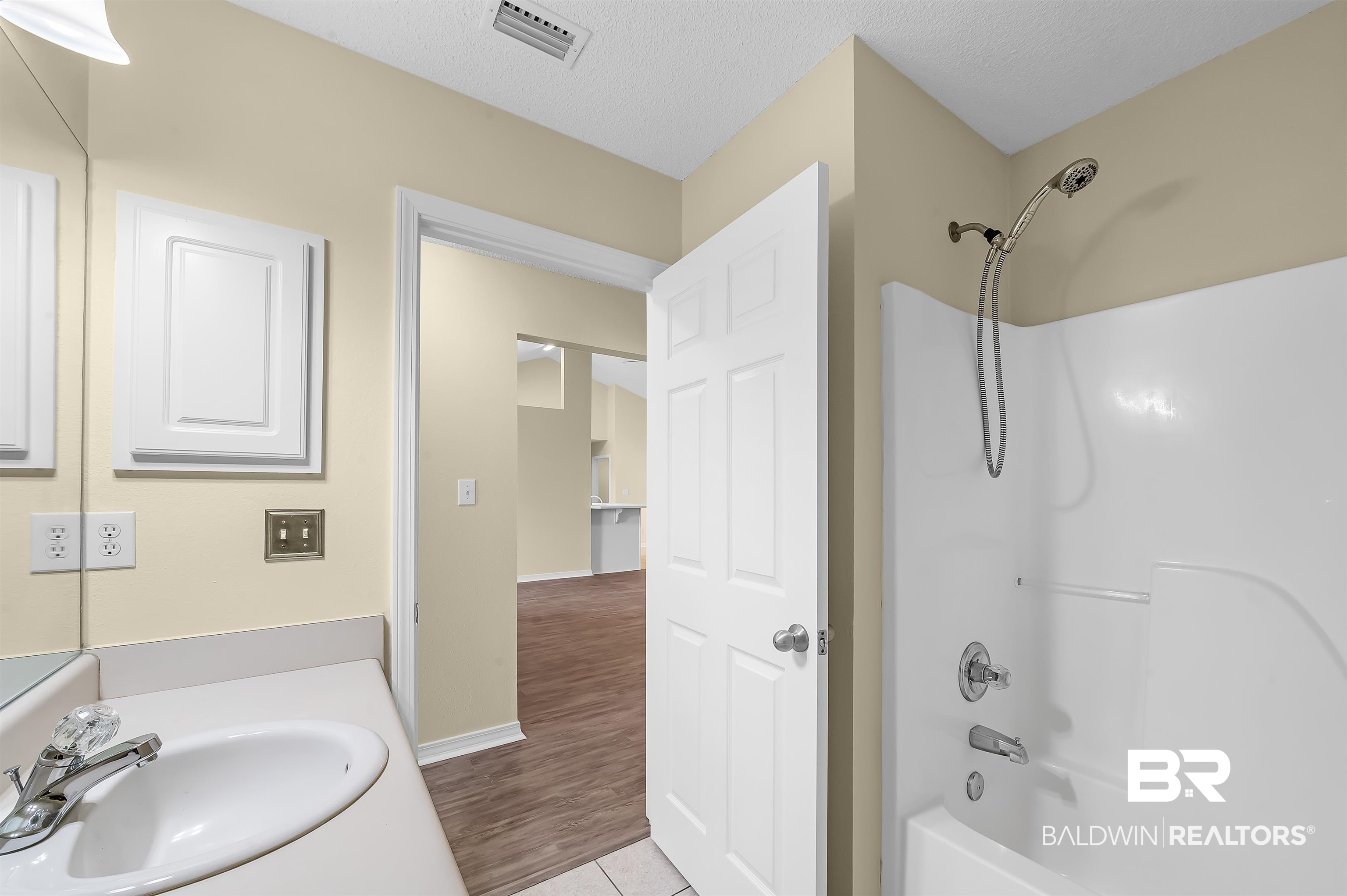12443 Venice Boulevard Foley, AL 36535 - Photo 52 of 59 Bathroom featuring hardwood / wood-style floors, a textured ceiling, shower / bathtub combination, and vanity