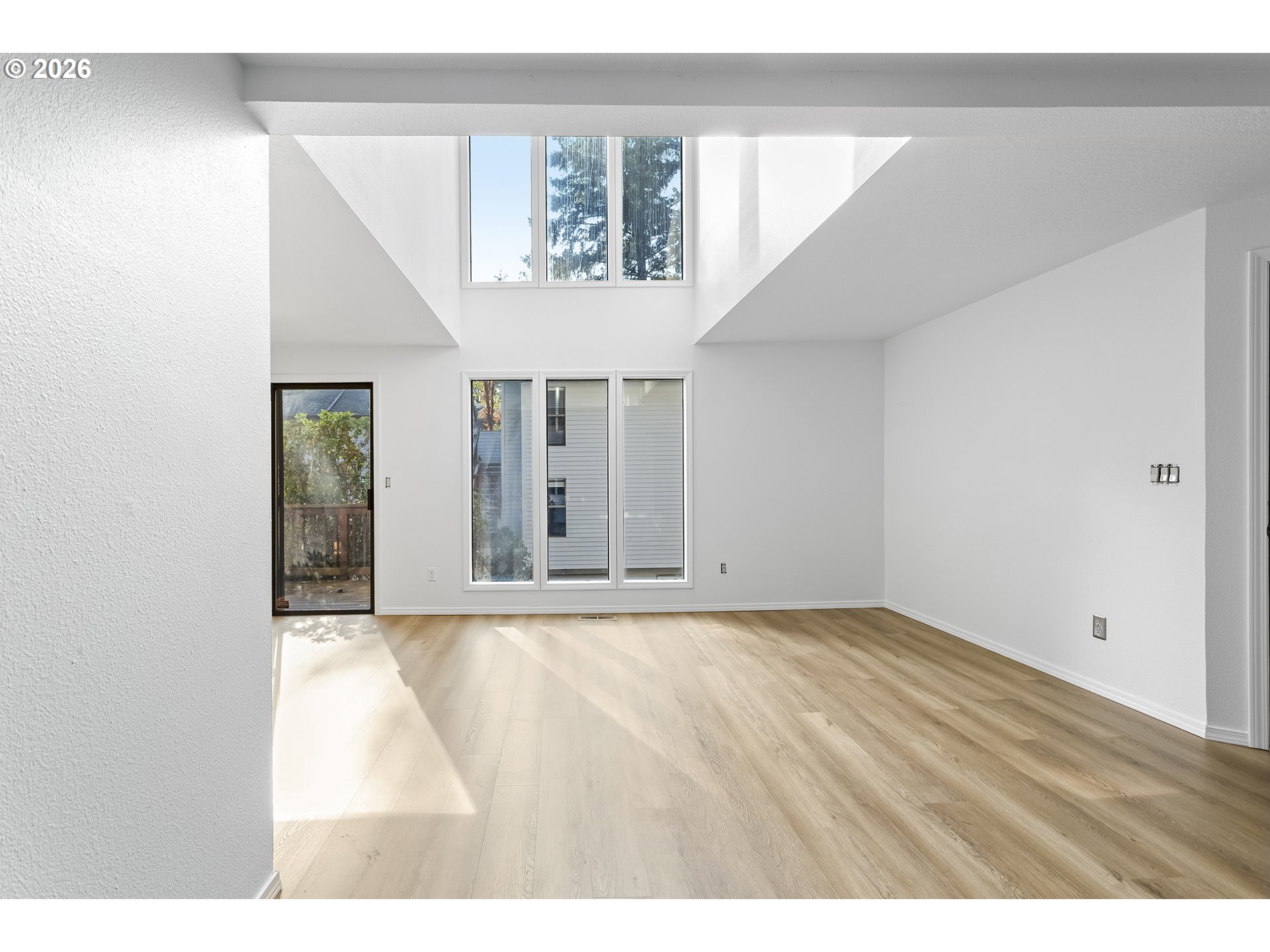 3676 Spring Lane Lake Oswego, OR 97035 - Photo 8 of 36 a view of an empty room with wooden floor and a window