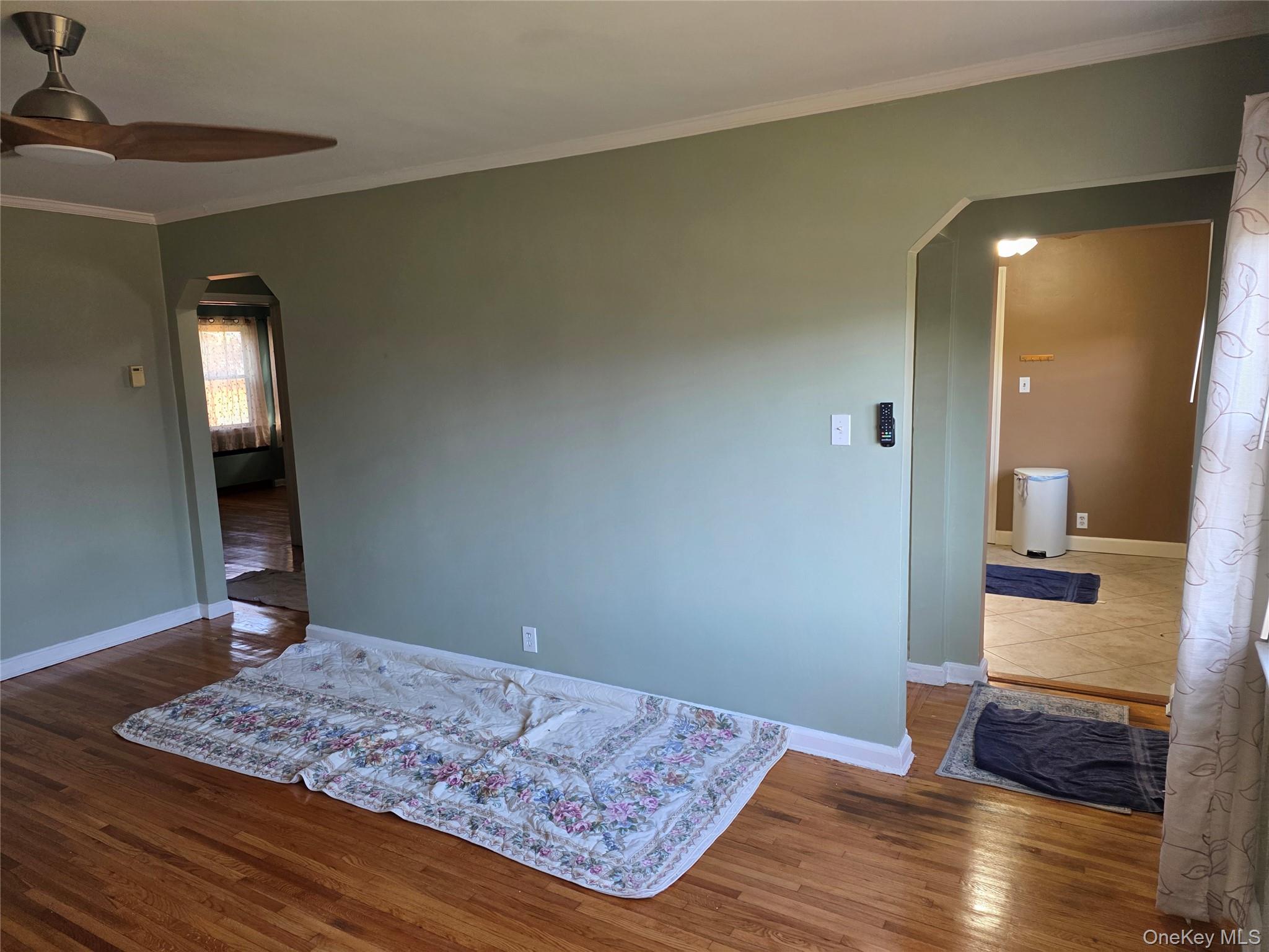 220 Raff Avenue Mineola, NY 11501 - Photo 8 of 22 Room featuring arched walkways, ornamental molding, dark wood finished floors, and ceiling fan
