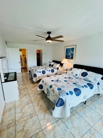 a bedroom with a bed and a view of kitchen