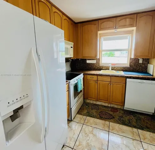 a kitchen with stainless steel appliances a stove a sink and a refrigerator