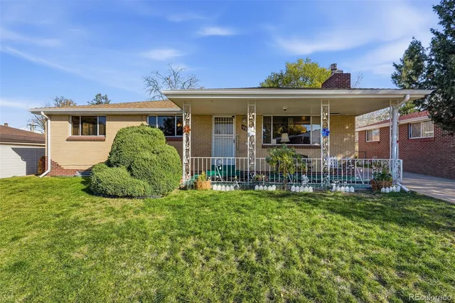 a view of a house with a porch and a yard