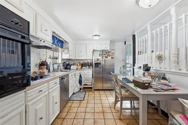 a kitchen with white cabinets and appliances