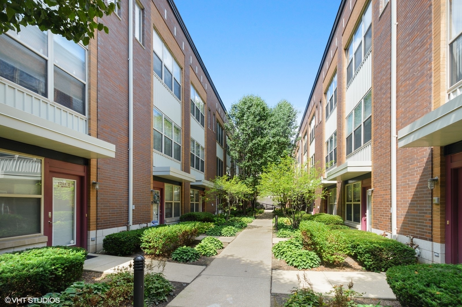 1244 West Monroe Street, Unit 4 Chicago, IL 60607 - Photo 2 of 16 a front view of a multi story building with yard and glass windows