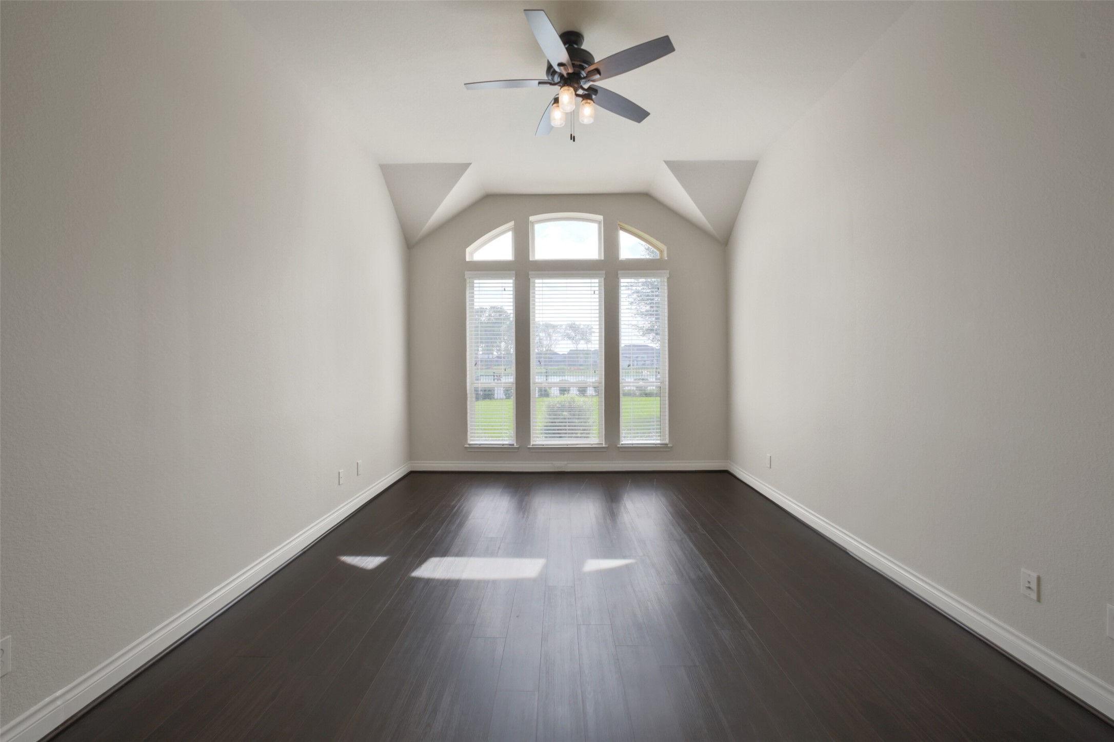 2707 River Run Road Missouri City, TX 77459 - Photo 20 of 45 an empty room with wooden floor chandelier fan and windows
