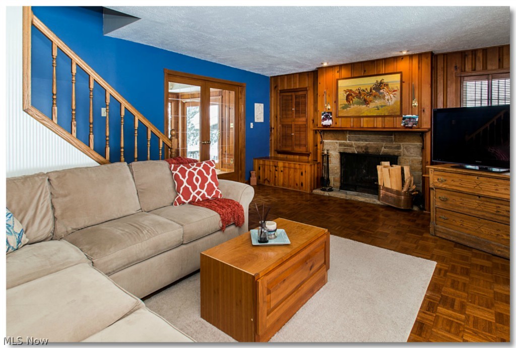 7901 Cedar Road Chesterland, OH 44026 - Photo 5 of 25 Living room, glass doors to dining room, stairs to 2nd floor, wood-burning fireplace, more built in storage.