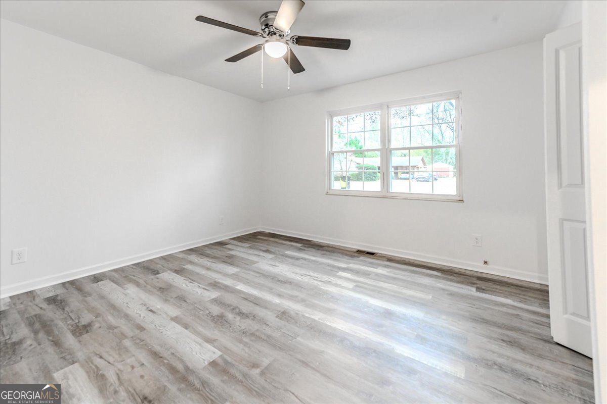111 Collins Street Byron, GA 31008 - Photo 11 of 26 a view of empty room with wooden floor and fan