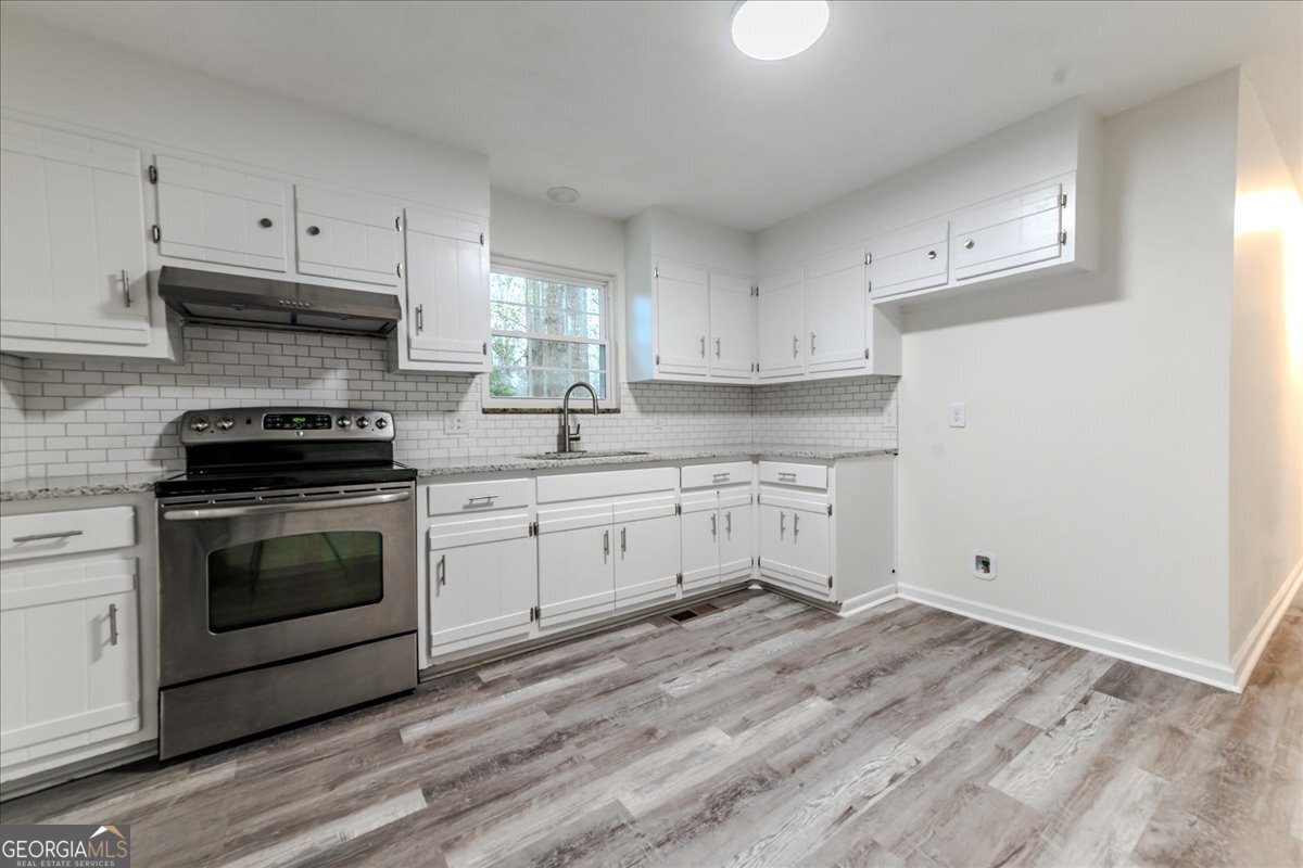 111 Collins Street Byron, GA 31008 - Photo 2 of 26 a kitchen with white cabinets white stainless steel appliances and sink