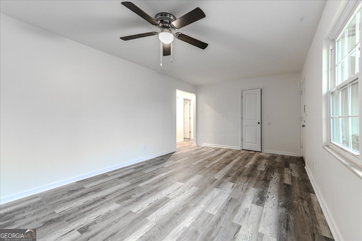 111 Collins Street Byron, GA 31008 - Photo 6 of 26 wooden floor in an empty room with a window
