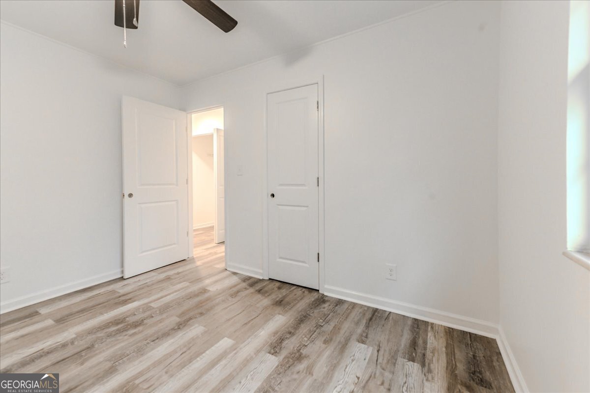 111 Collins Street Byron, GA 31008 - Photo 10 of 26 an empty room with wooden floor cabinet and windows