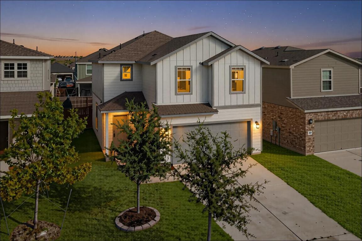 a front view of a house with a yard and trees