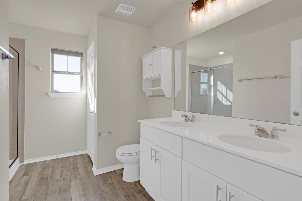 449 Stone Water Lane Jarrell, TX 76537 - Photo 11 of 21 a bathroom with a sink a toilet and shower