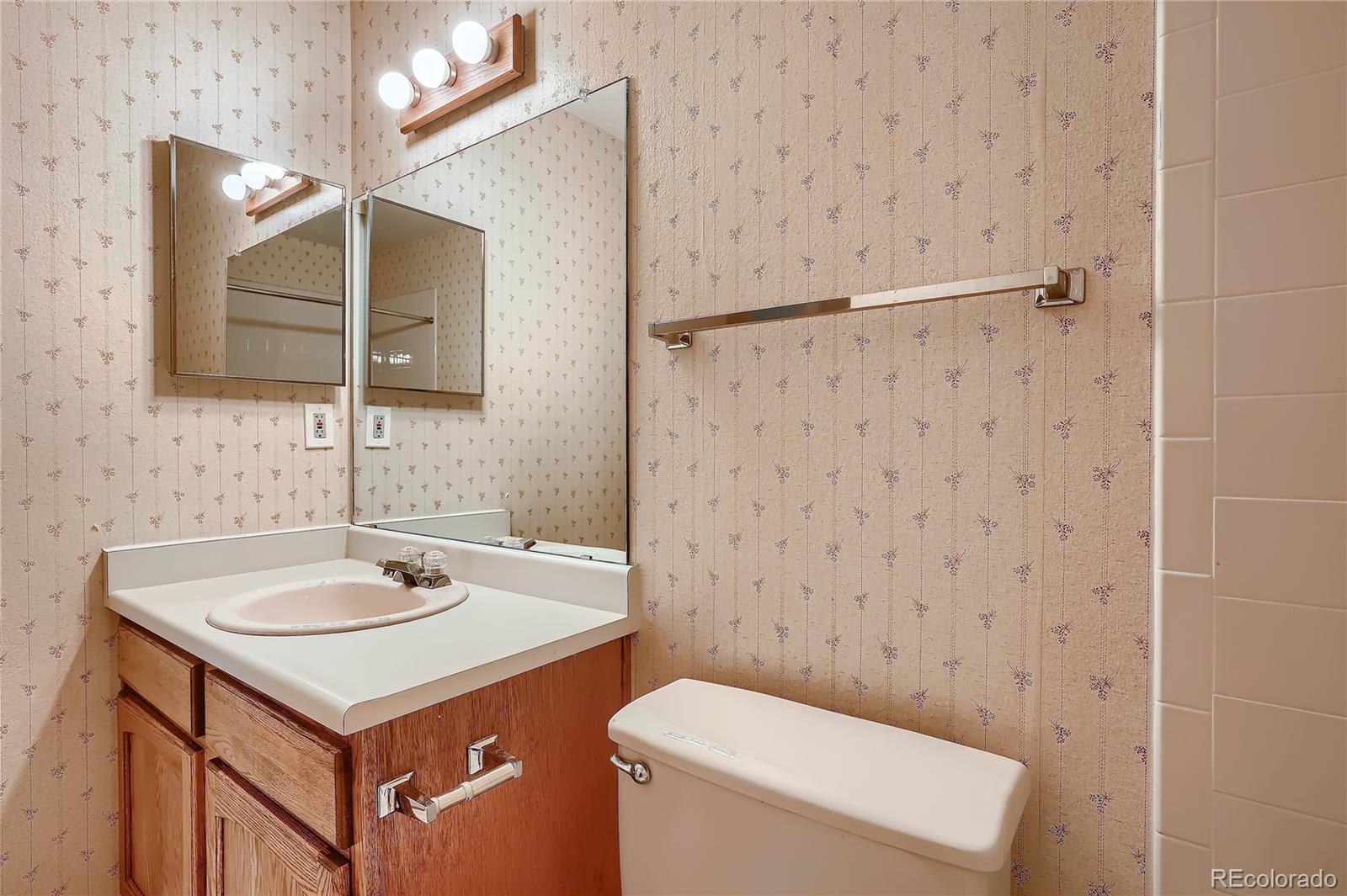 6 Shetland Court Highlands Ranch, CO 80130 - Photo 25 of 33 a bathroom with a sink toilet and mirror