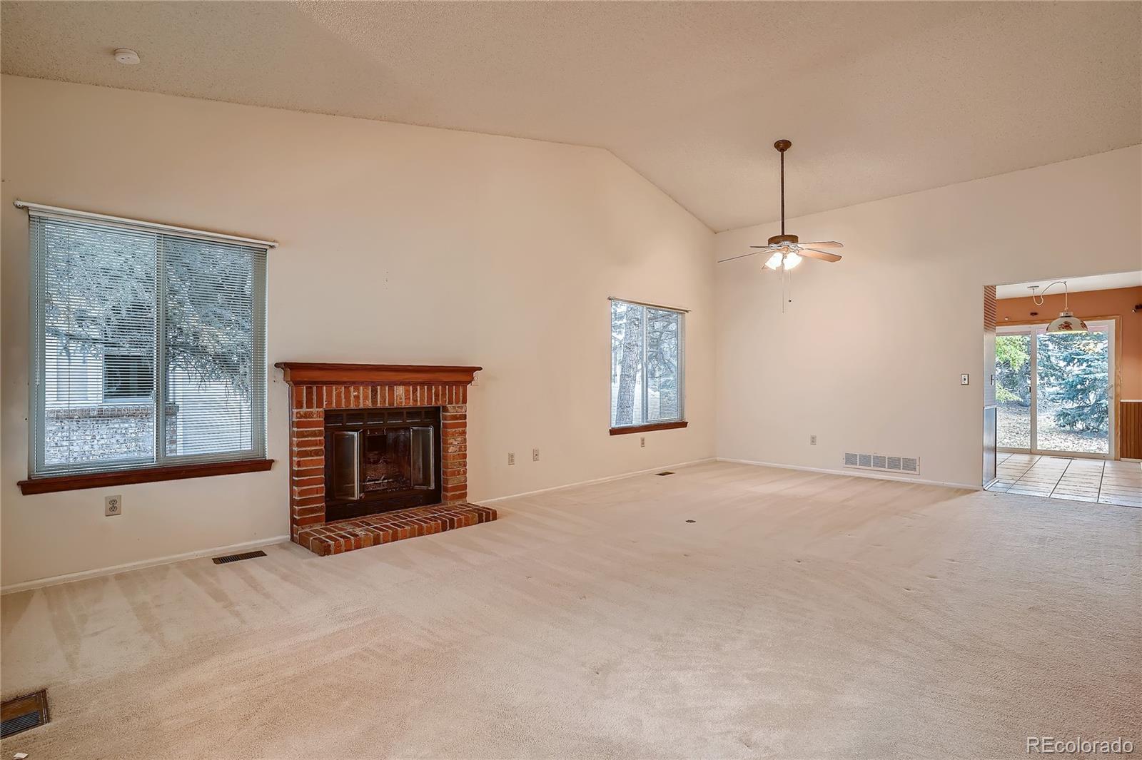 6 Shetland Court Highlands Ranch, CO 80130 - Photo 8 of 33 an empty room with windows fireplace and windows