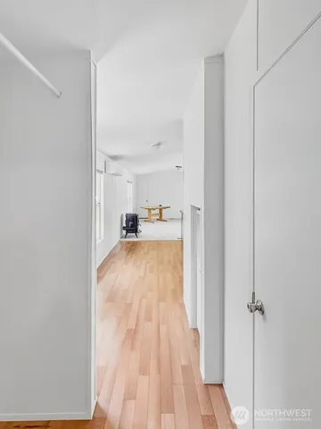 a view of a room that has a bed and wooden floor