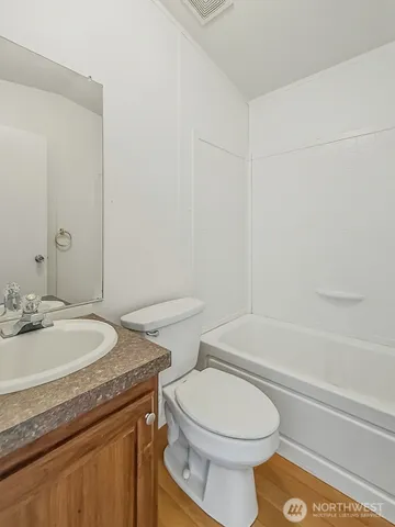 a bathroom with a granite countertop toilet sink and mirror