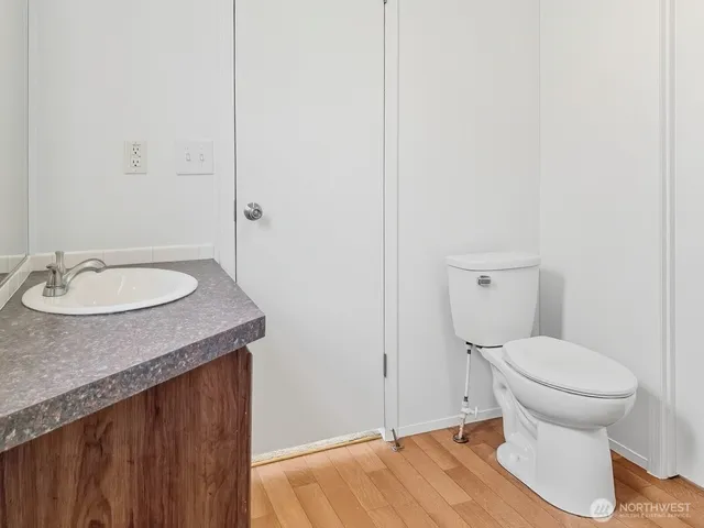 a bathroom with a granite countertop toilet and a sink