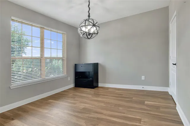a view of a hallway with wooden floor and entryway