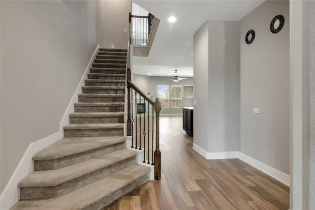 a view of a livingroom with a ceiling fan and hardwood floor