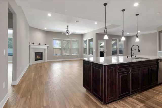 a kitchen with kitchen island granite countertop a sink island and wooden cabinets
