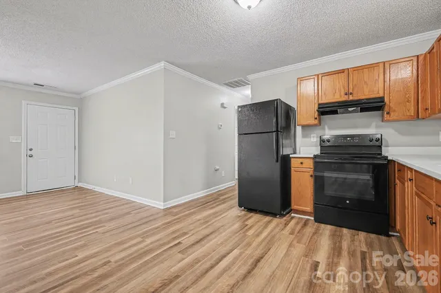 a kitchen with a refrigerator stove and wooden cabinets
