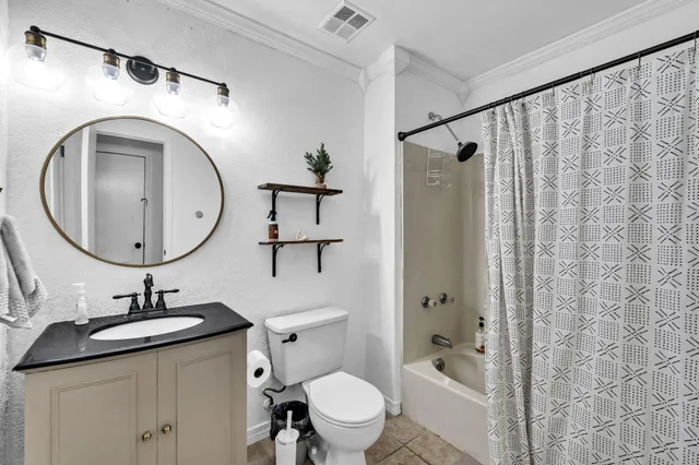 a bathroom with a granite countertop sink mirror vanity and toilet