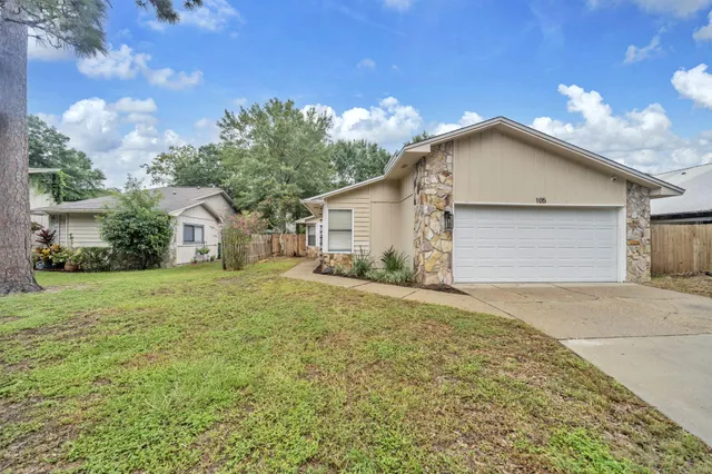 a view of backyard of house with wooden fence