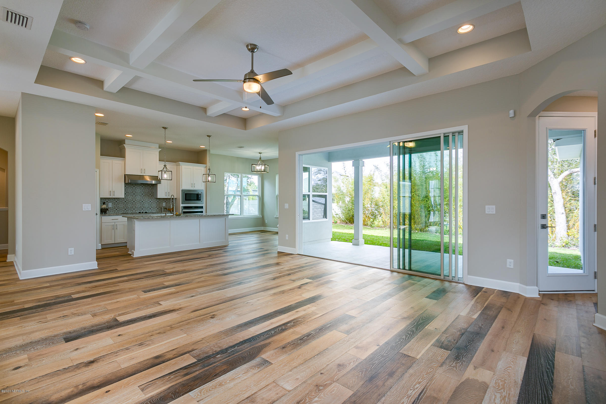 596 West Bianca Circle St. Augustine, FL 32086 - Photo 10 of 37 a view of an empty room with wooden floor and a kitchen