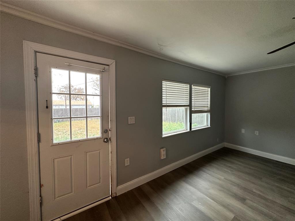 2058 Collins Avenue Abilene, TX 79603 - Photo 4 of 11 an empty room with wooden floor and windows