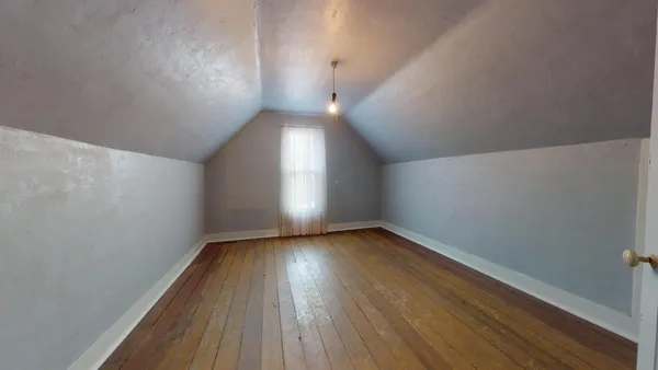 a view of an empty room and wooden floor